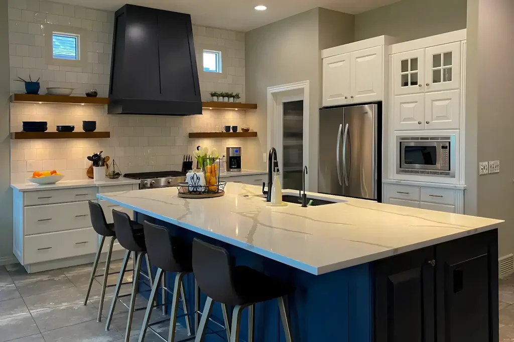 Modern kitchen showcasing expertly painted white cabinets and a bold blue island with a white quartz countertop. Repainting Kitchen Cabinets in Calgary