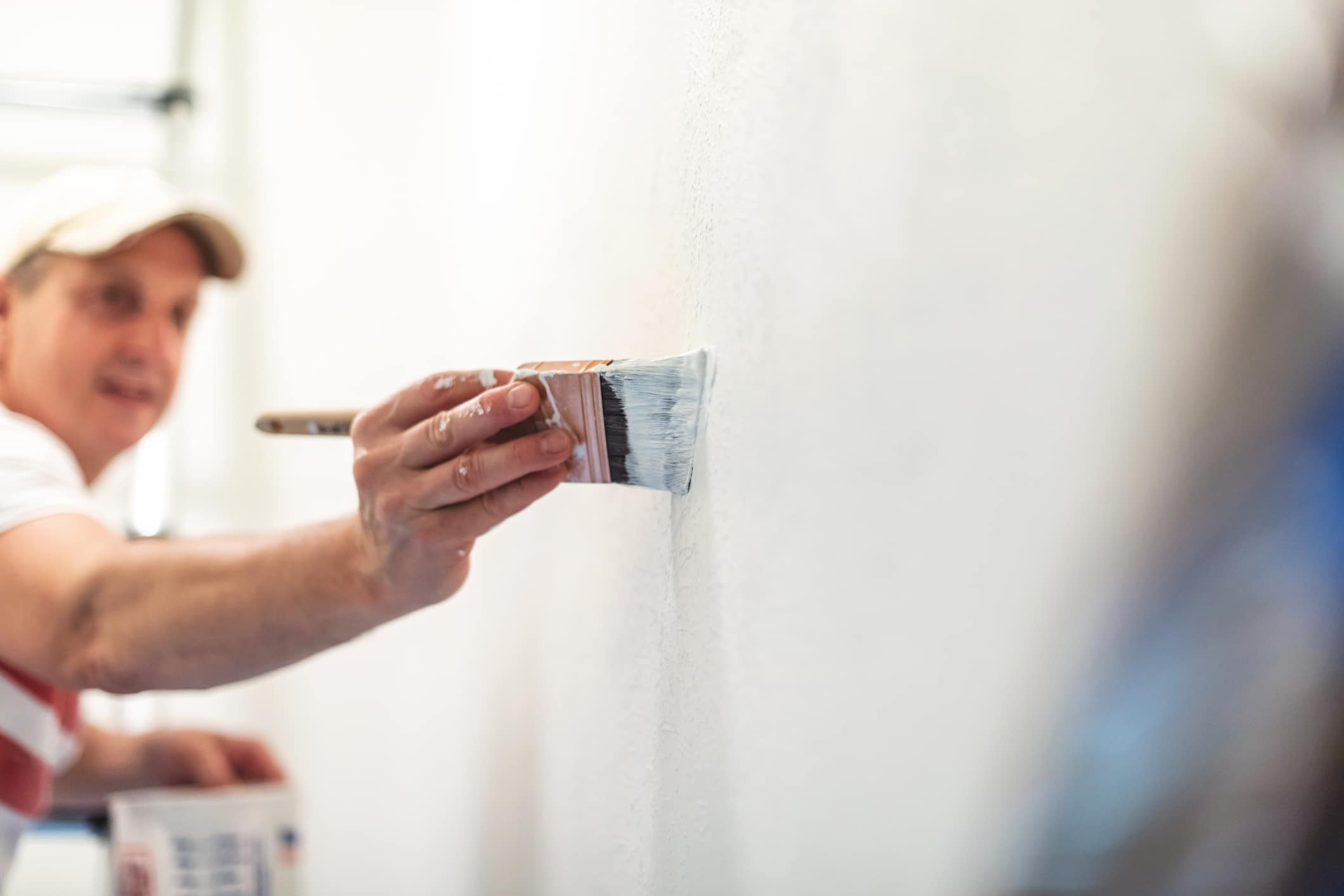 Mature Adult Male Painting With White Wall Paint