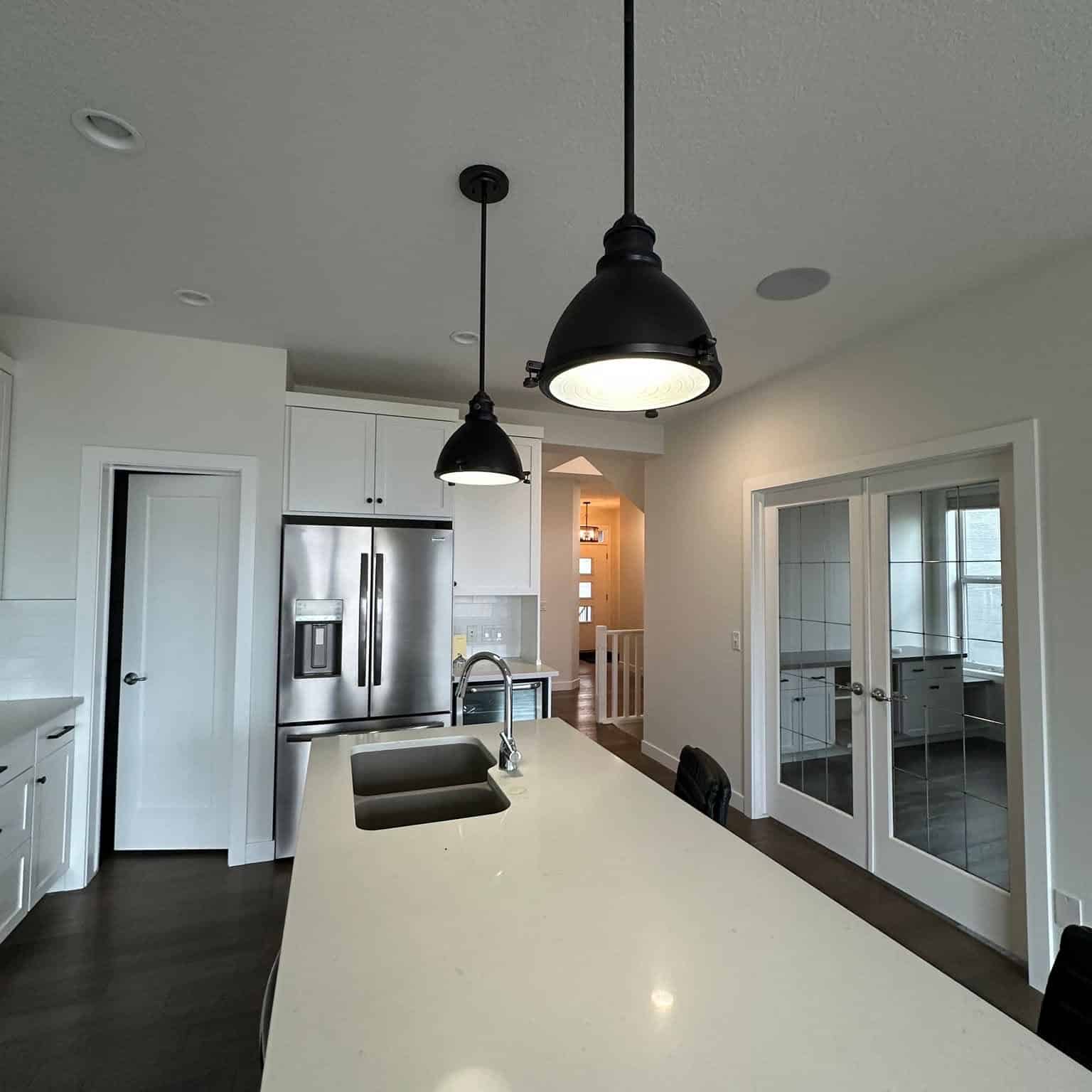 Bright open concept kitchen with freshly painted white cabinets, neutral walls, and a spacious island.